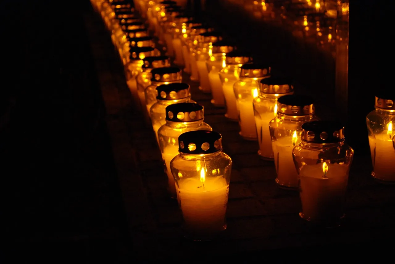 Rows of lit candles at a cemetery