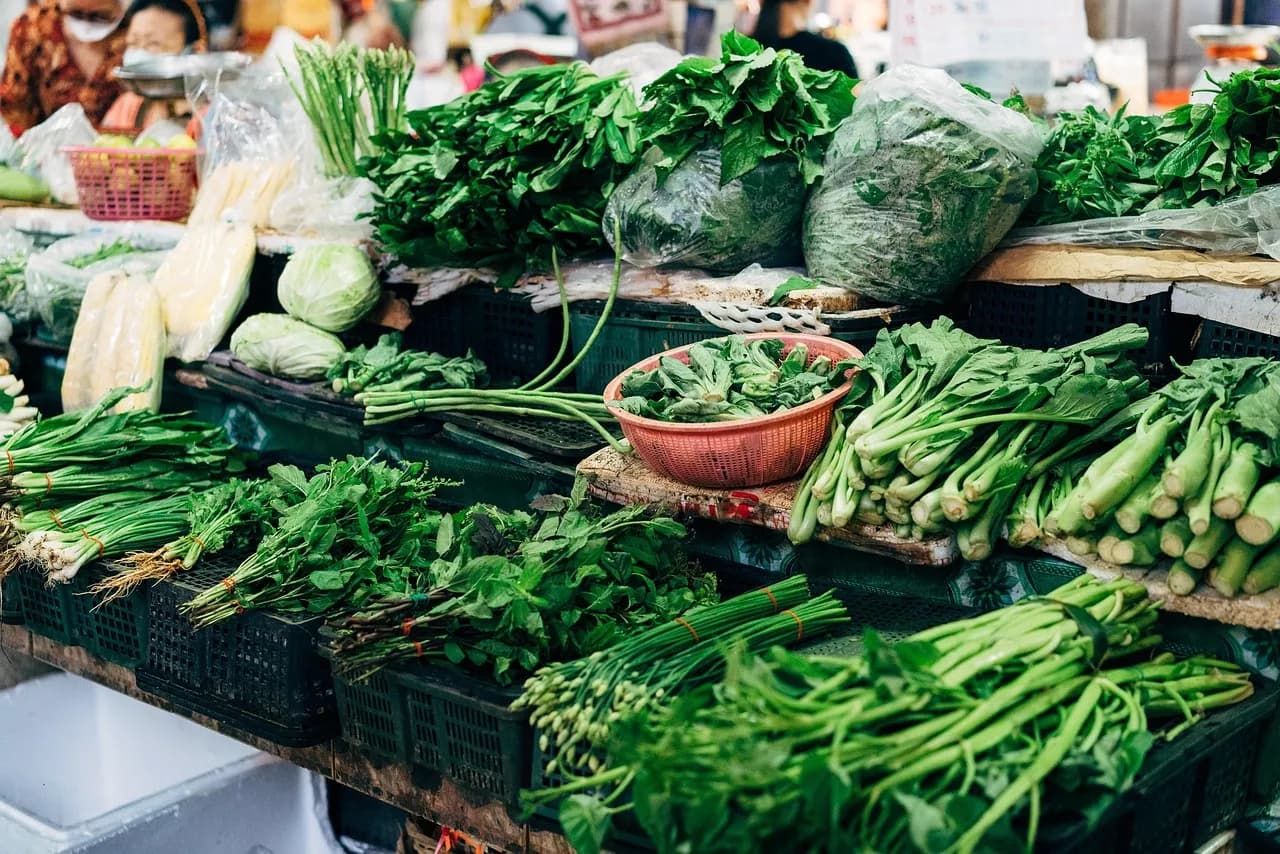 Fresh green vegetables piled on a market stall